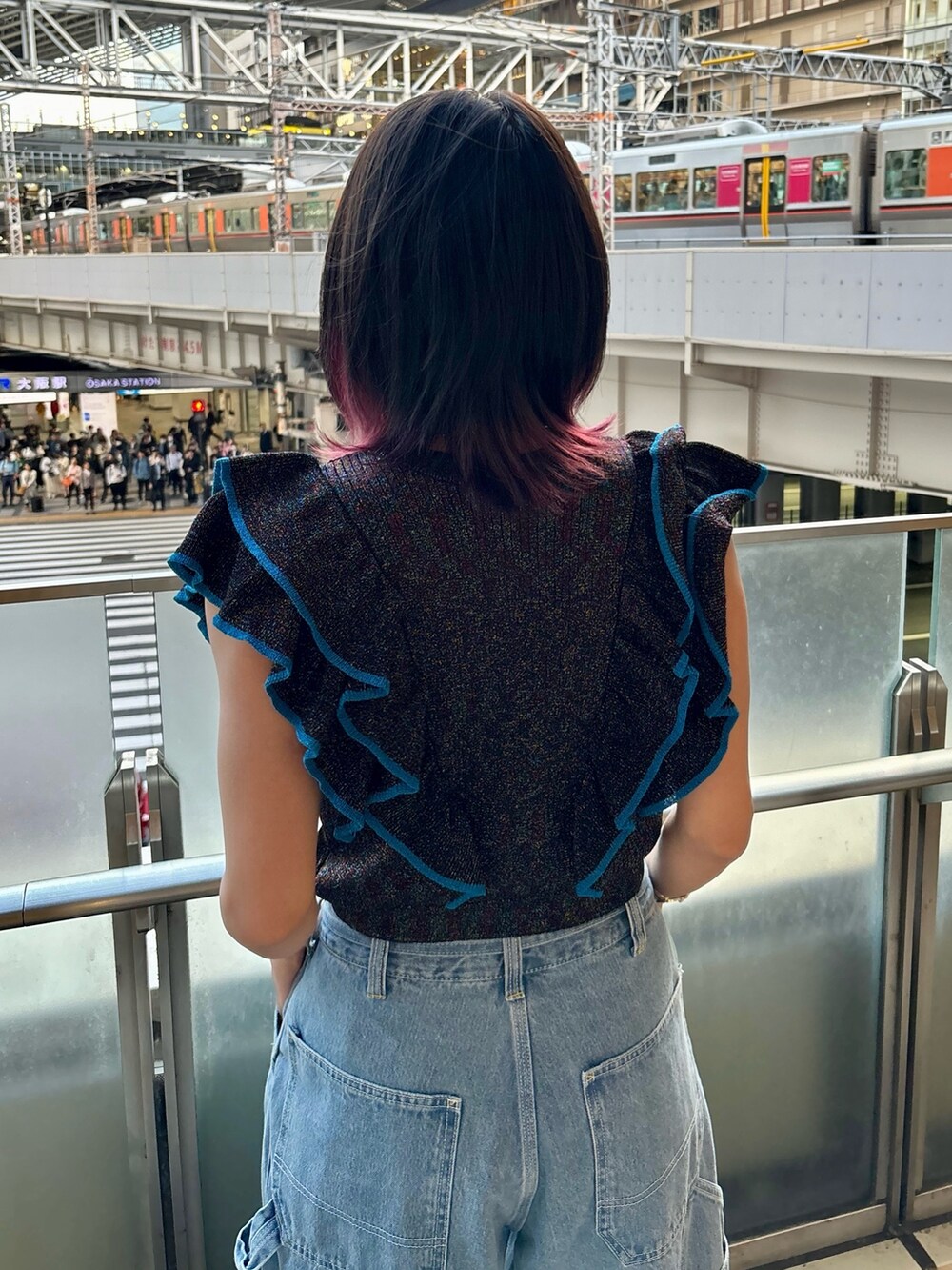 ブルー系のデニムパンツ、ブラック系のニット/セーター、シルバー系のブレスレットを着用したレディースの夏コーディネートの5枚目の写真