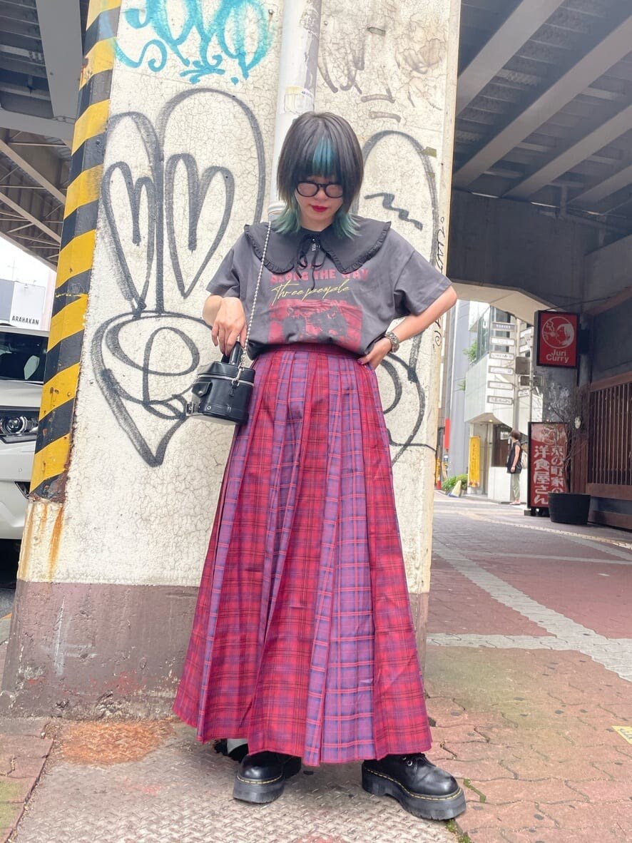 ブラック系のショルダーバッグ、ブラック系のTシャツ/カットソー、レッド系のスカートを着用したレディースの夏コーディネートの2枚目の写真