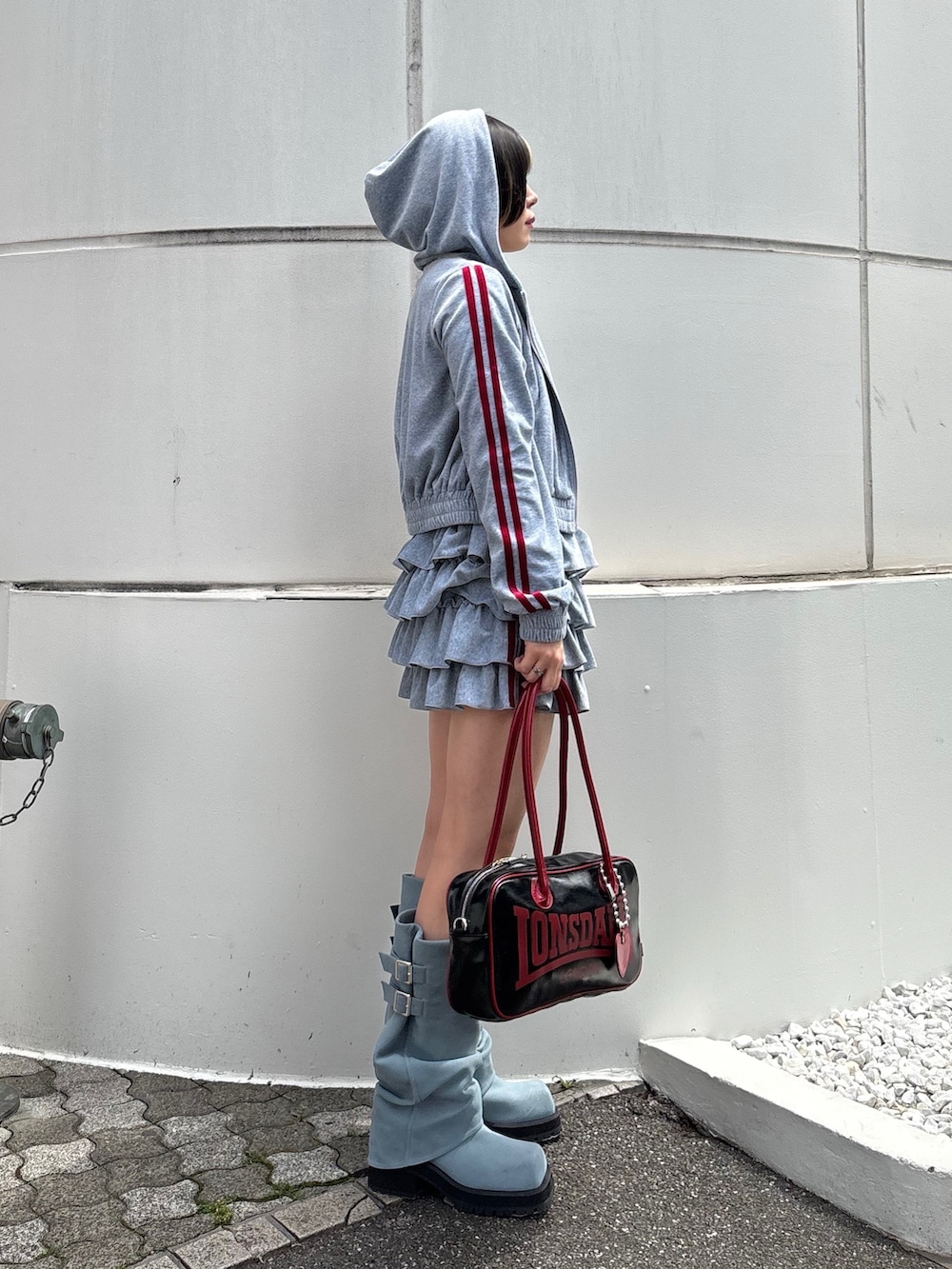 ブラック系のボストンバッグ、ブルー系のブーツ、ブラック系のTシャツ/カットソーを着用したレディースの春コーディネートの4枚目の写真