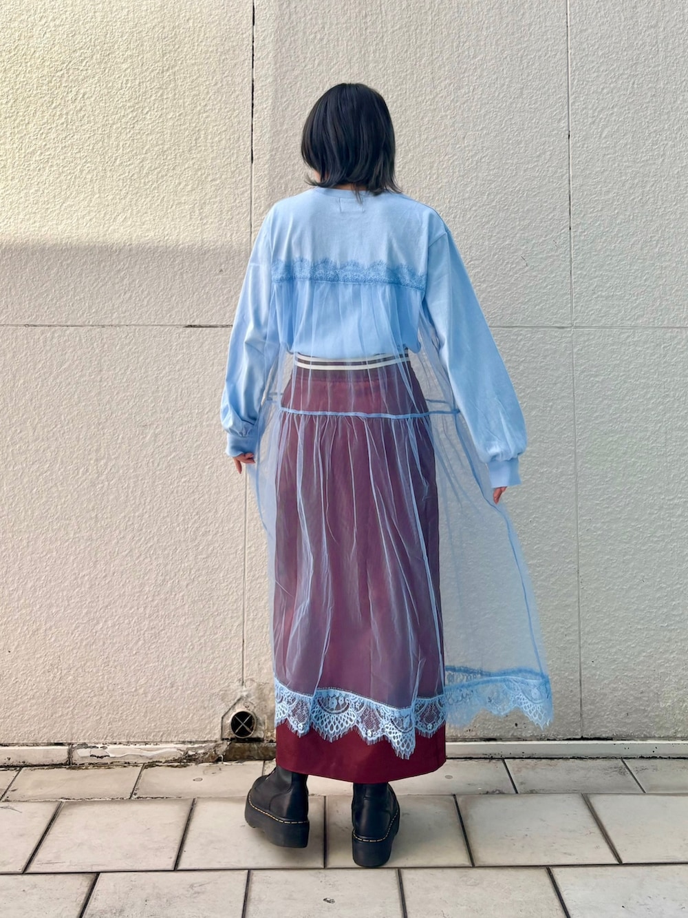 レッド系のスカート、ブルー系のワンピースを着用したレディースの冬コーディネートの5枚目の写真