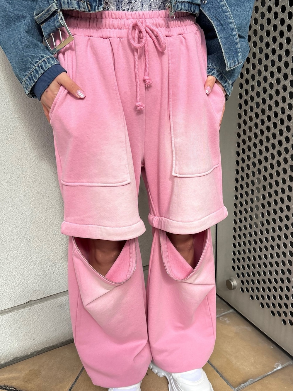 ホワイト系のスニーカー、ピンク系のスウェットパンツ、ブルー系のライダースジャケットを着用したレディースの春コーディネートの9枚目の写真