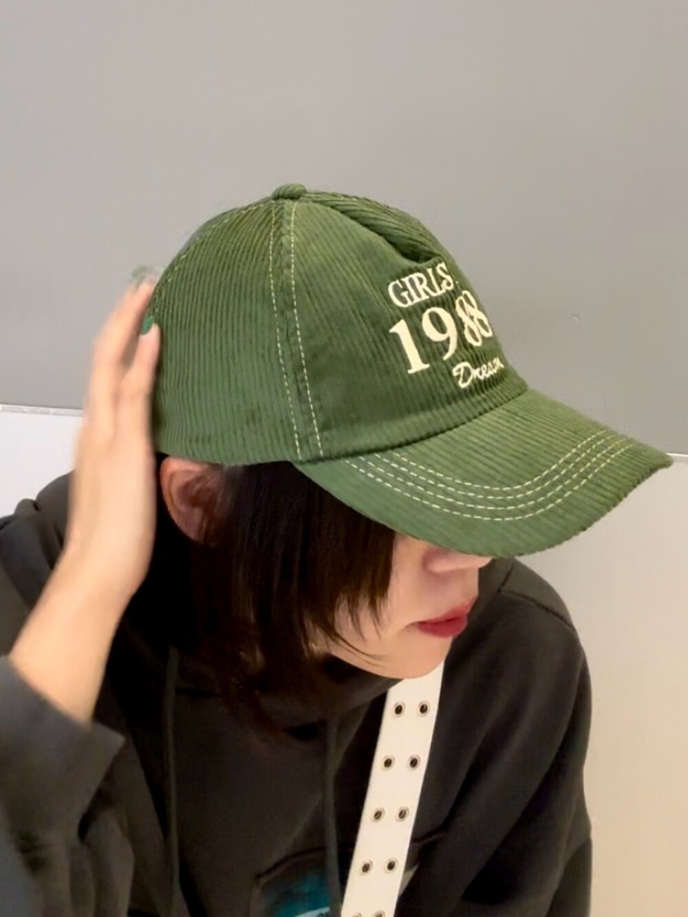 レッド系のワンピース、グレー系のパーカー、ホワイト系のショルダーバッグを着用したレディースの秋コーディネートの10枚目の写真