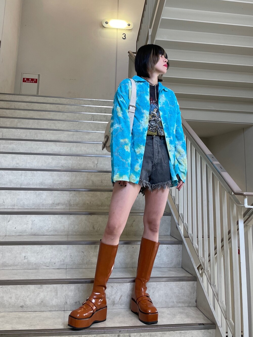 ブラック系のデニムパンツ、ブルー系のシャツ/ブラウス、ブラック系のTシャツ/カットソーを着用したレディースの春コーディネートの4枚目の写真
