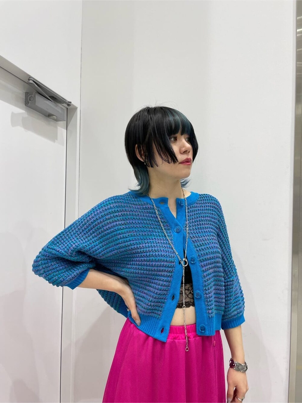 ピンク系のスカート、ブルー系のカーディガン/ボレロ、ホワイト系のその他シューズを着用したレディースの春コーディネートの3枚目の写真