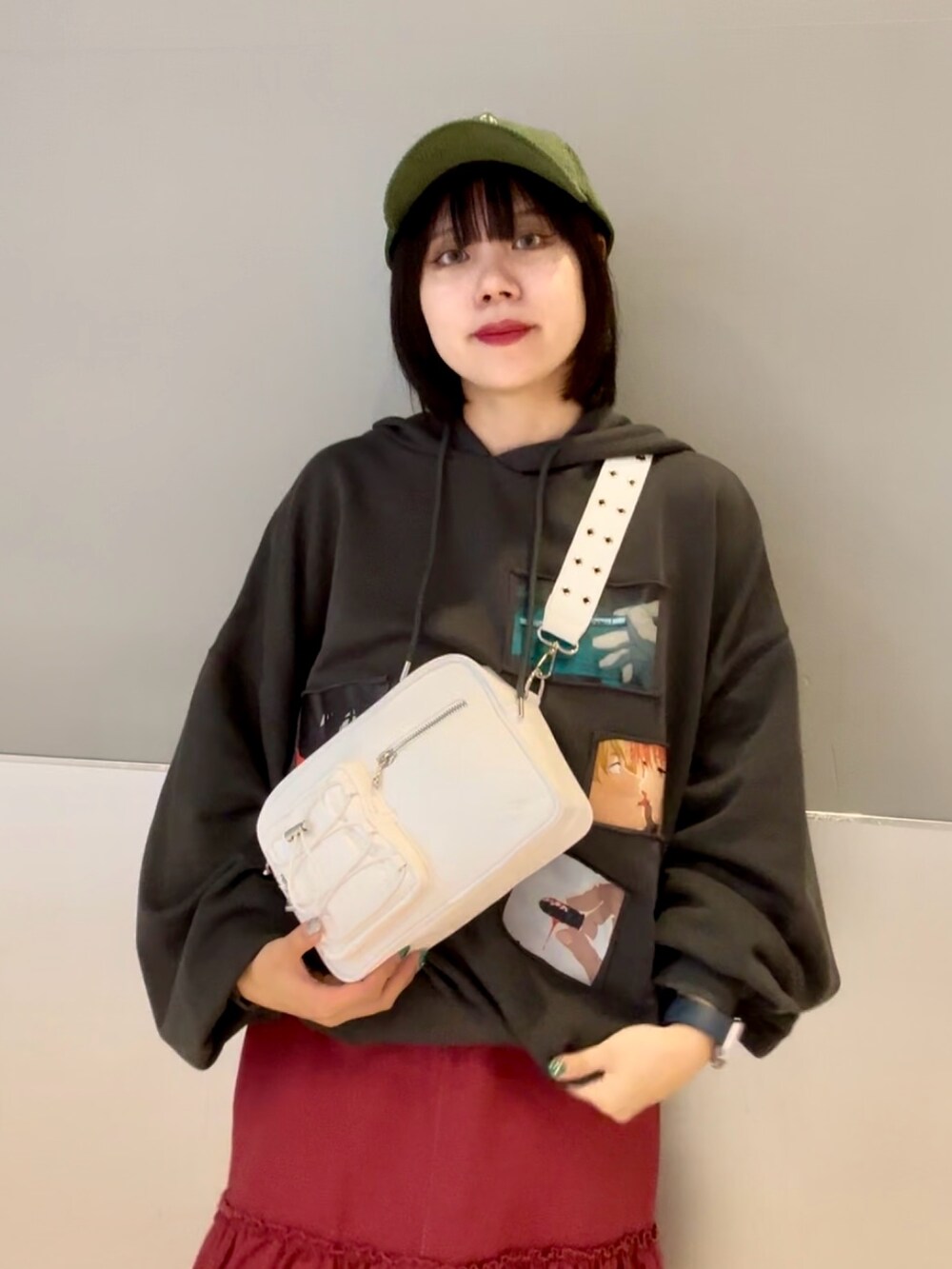 レッド系のワンピース、グレー系のパーカー、ホワイト系のショルダーバッグを着用したレディースの秋コーディネートの7枚目の写真