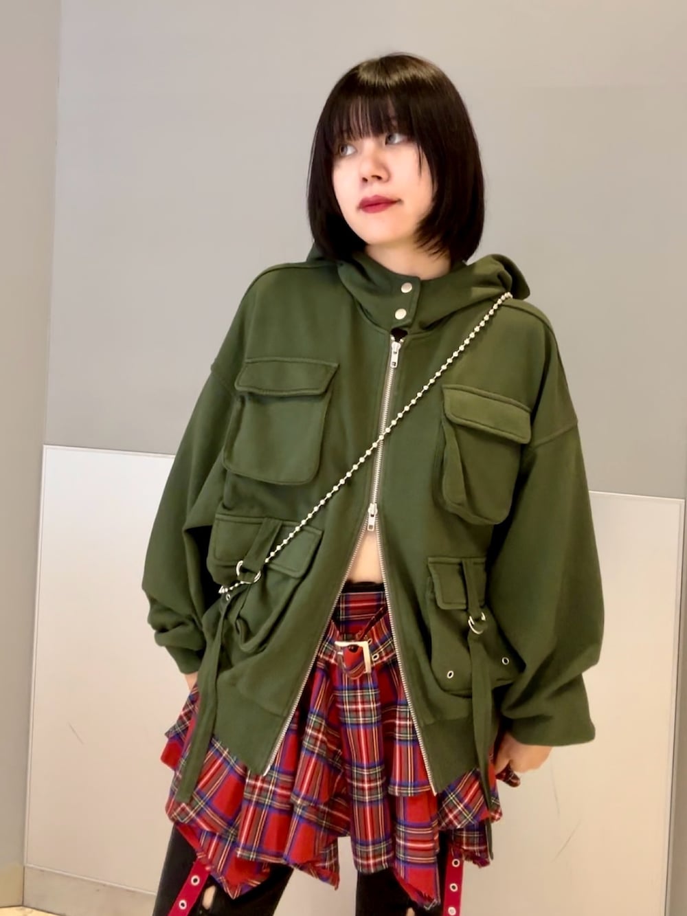 ブラック系のハンドバッグ、ブラック系のデニムパンツ、グリーン系のパーカーを着用したレディースの秋コーディネートの7枚目の写真