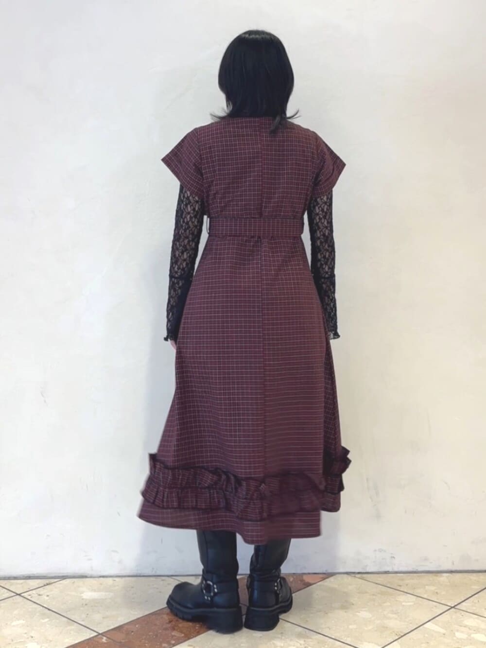 レッド系のワンピース、ブラック系のTシャツ/カットソー、ブラウン系のチョーカーを着用したレディースの春コーディネートの3枚目の写真