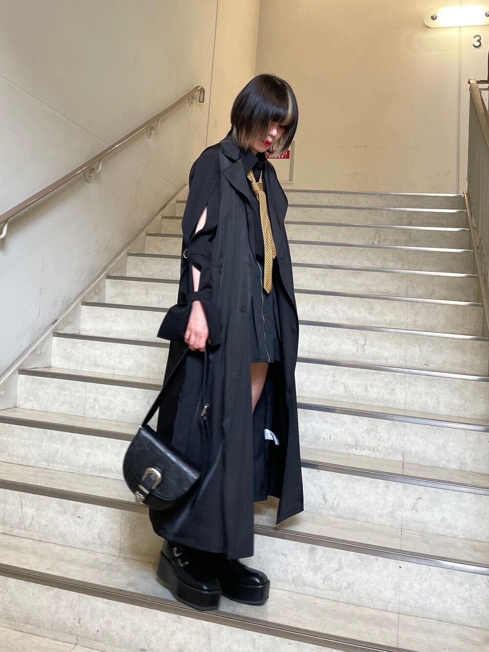 ブラック系のブーツ、ブラック系のシャツ/ブラウス、ブラック系のショルダーバッグを着用したレディースの春コーディネートの5枚目の写真