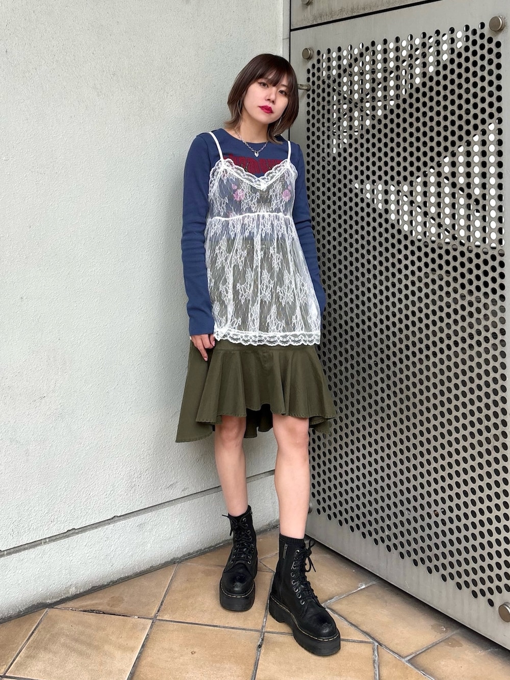 グリーン系のスカート、ブルー系のTシャツ/カットソー、ホワイト系のキャミソールを着用したレディースの冬コーディネートの3枚目の写真