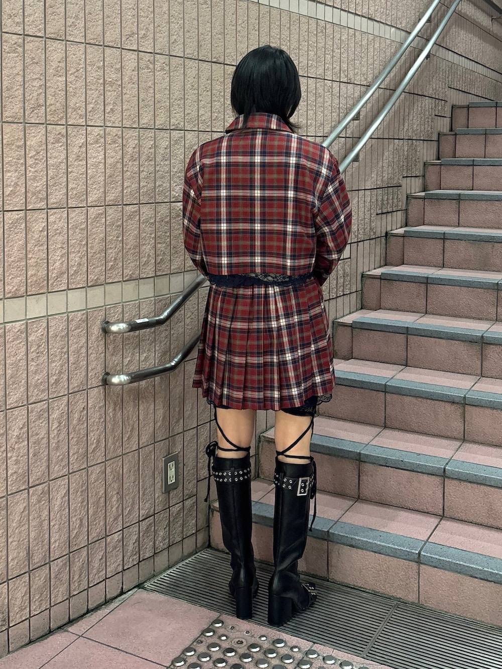 レッド系のスカート、レッド系のテーラードジャケット、ブラック系のTシャツ/カットソーを着用したレディースの冬コーディネートの2枚目の写真