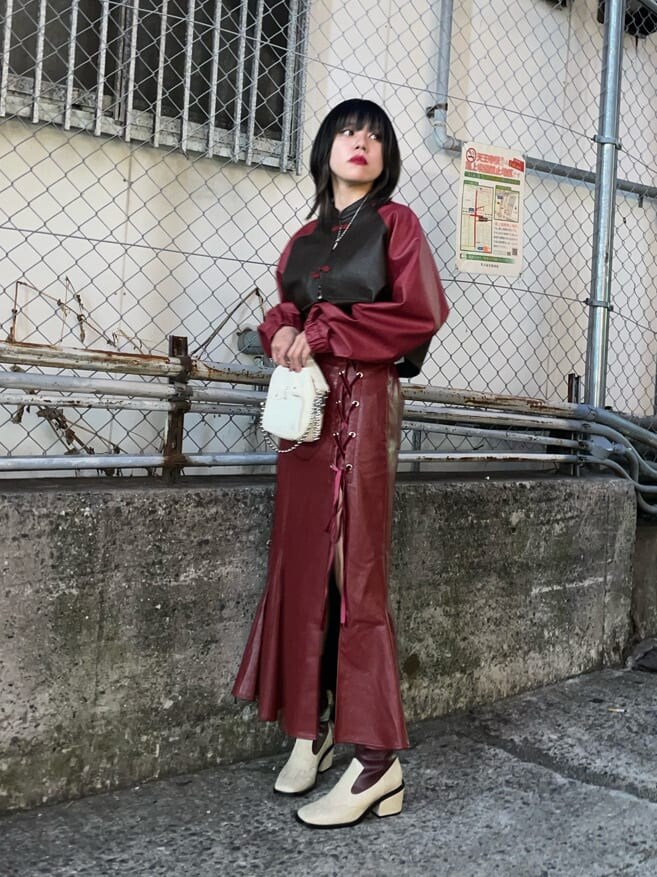 ブラウン系のブルゾン、レッド系のスカート、その他のキャミソールを着用したレディースの秋コーディネートの7枚目の写真