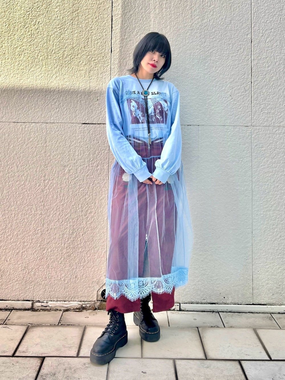 レッド系のスカート、ブルー系のワンピースを着用したレディースの冬コーディネートの3枚目の写真