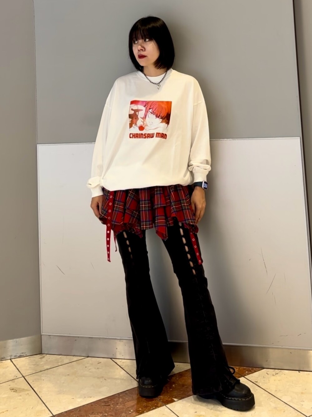 ブラック系のデニムパンツ、レッド系のスカート、ホワイト系のTシャツ/カットソーを着用したレディースの秋コーディネートの2枚目の写真