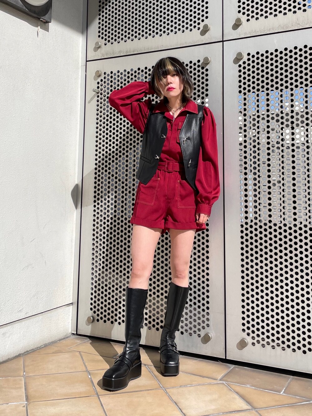 ブラック系のブーツ、ブラック系のベスト、レッド系のつなぎ/オールインワンを着用したレディースの春コーディネートの4枚目の写真