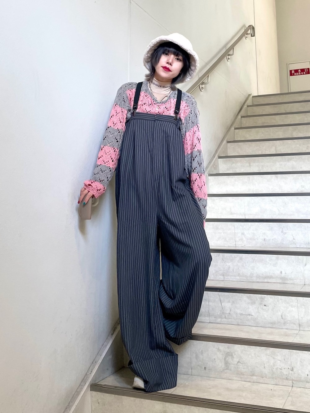 グレー系のつなぎ/オールインワン、ホワイト系のスニーカー、ベージュ系のTシャツ/カットソーを着用したレディースの冬コーディネートの2枚目の写真