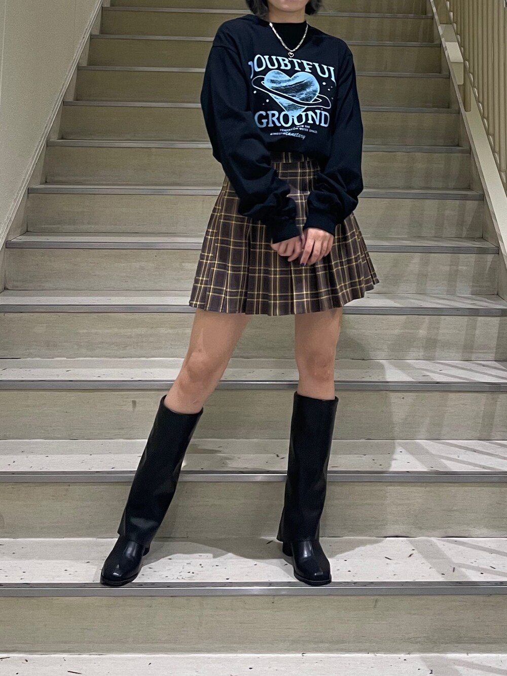 ブラック系のTシャツ/カットソー、ブルー系のブルゾン、ブラック系のブーツを着用したレディースの秋コーディネートの5枚目の写真