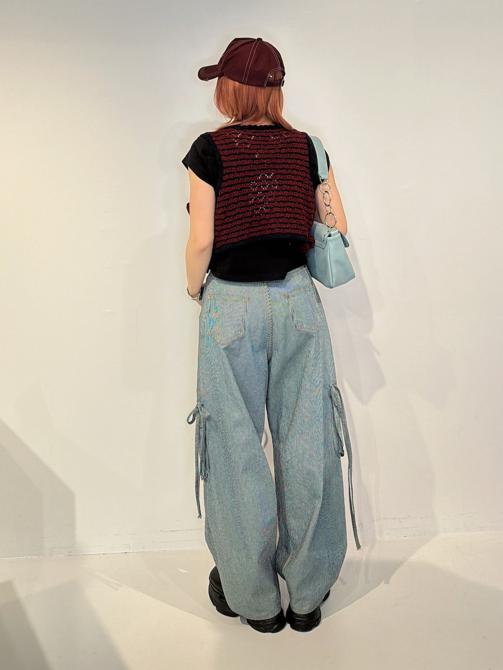 ブラック系のデニムパンツ、レッド系のその他トップスを着用したレディースの冬コーディネートの4枚目の写真