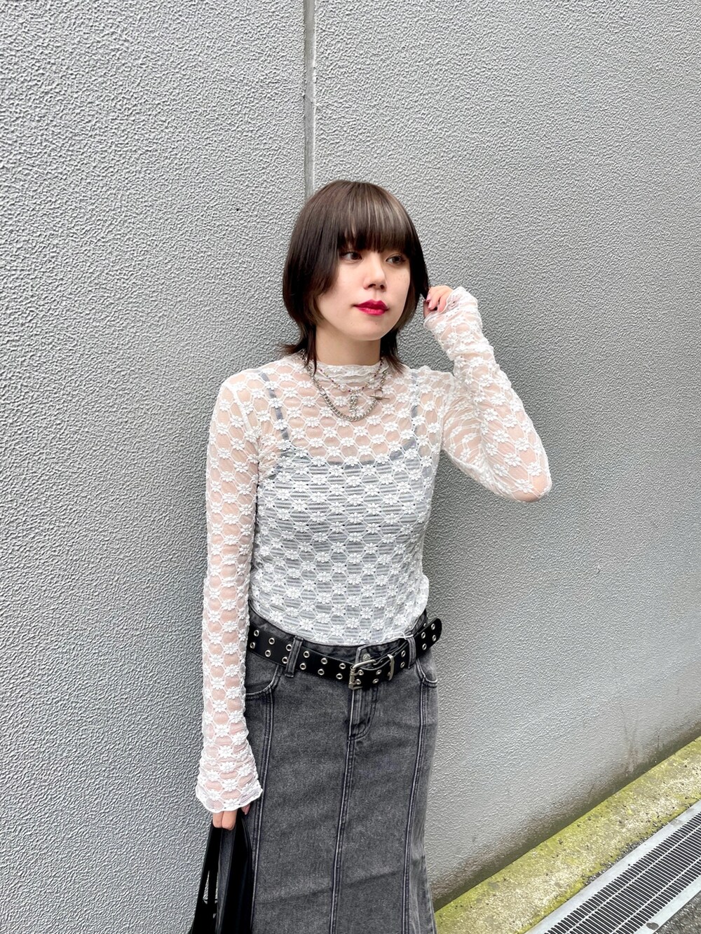 ホワイト系のTシャツ/カットソー、ブラック系のバックパック/リュック、ブラック系のデニムスカートを着用したレディースの夏コーディネートの8枚目の写真