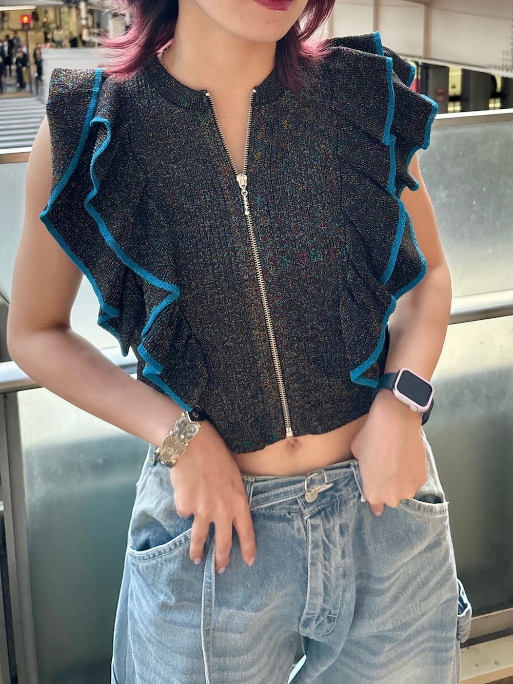 ブルー系のデニムパンツ、ブラック系のニット/セーター、シルバー系のブレスレットを着用したレディースの夏コーディネートの4枚目の写真