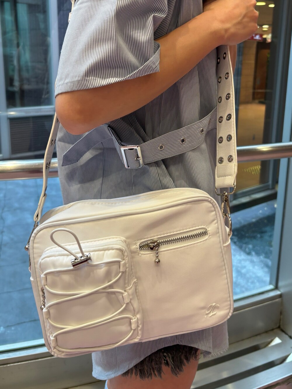 ブルー系のシャツ/ブラウス、ホワイト系のショルダーバッグ、ブラック系のデニムパンツを着用したレディースの夏コーディネートの9枚目の写真