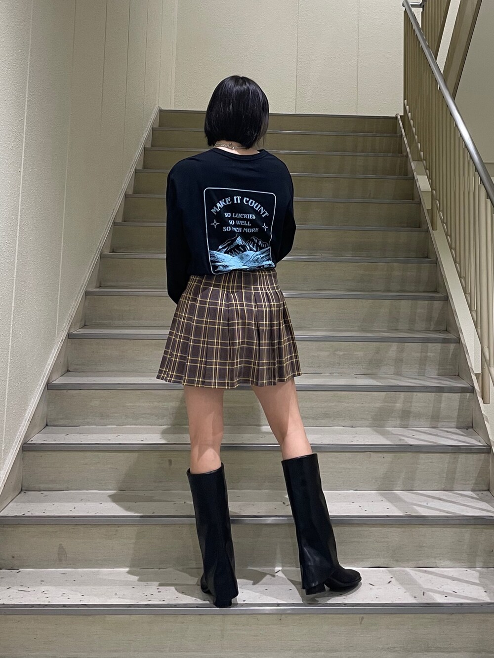 ブラック系のTシャツ/カットソー、ブルー系のブルゾン、ブラック系のブーツを着用したレディースの秋コーディネートの6枚目の写真