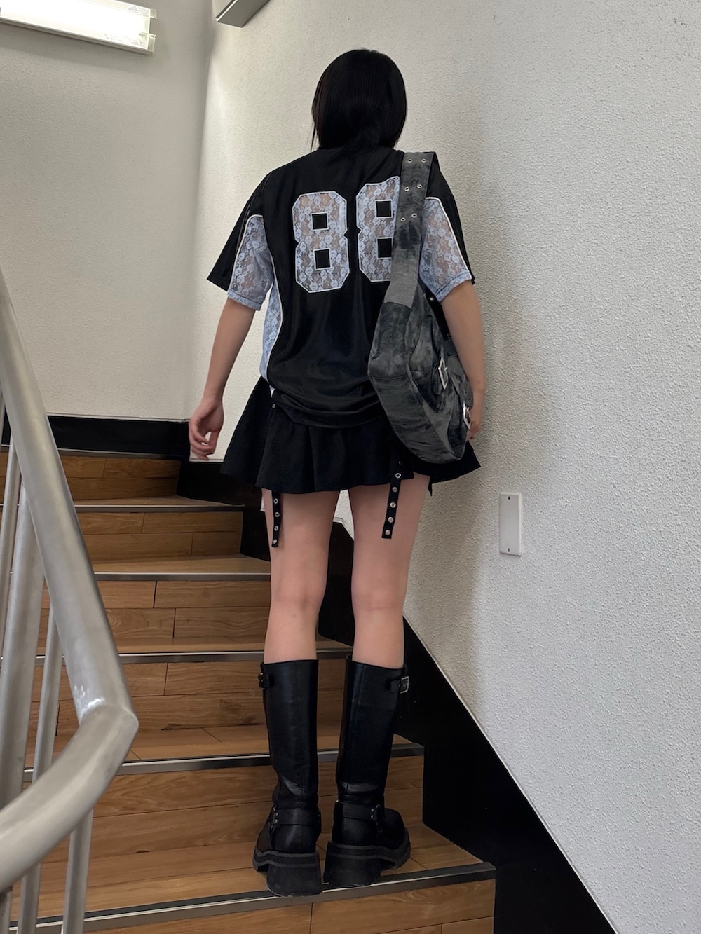 ブラック系のスカート、ブラック系のメッセンジャーバッグ、ブラック系のTシャツ/カットソーを着用したレディースの春コーディネートの4枚目の写真