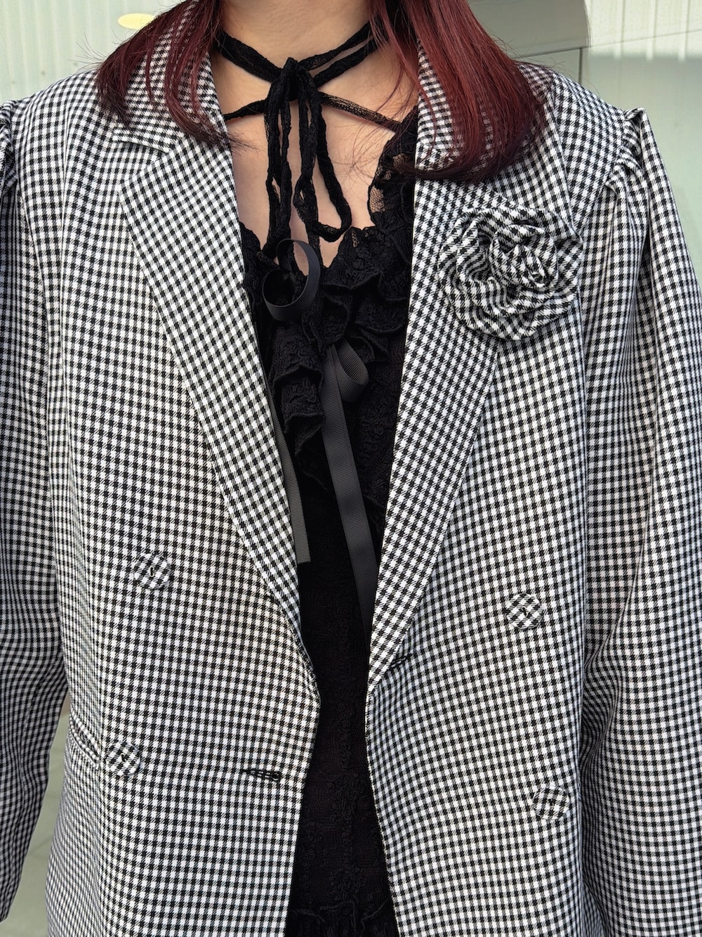 ブラック系のワンピース、ブラック系のテーラードジャケット、シルバー系のハンドバッグを着用したレディースの冬コーディネートの6枚目の写真