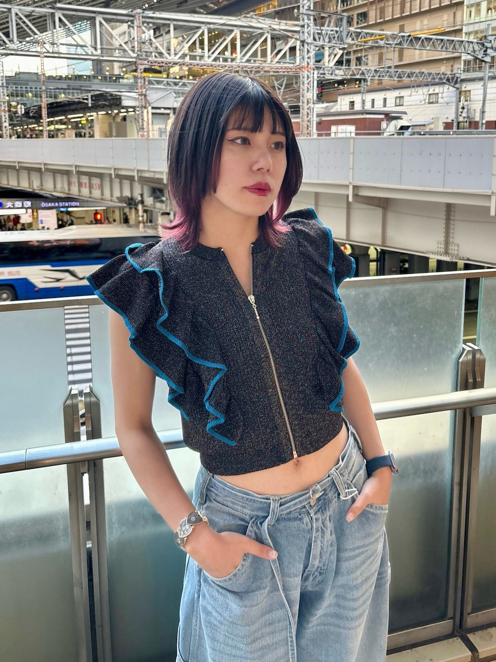 ブルー系のデニムパンツ、ブラック系のニット/セーター、シルバー系のブレスレットを着用したレディースの夏コーディネートの3枚目の写真