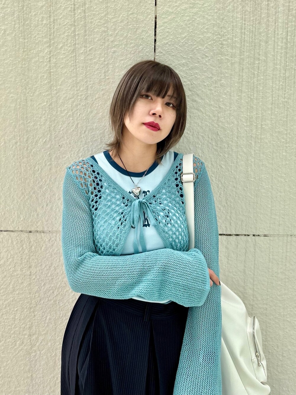 ブルー系のスカート、ブルー系のデニムパンツ、ブルー系のタンクトップを着用したレディースの春コーディネートの5枚目の写真