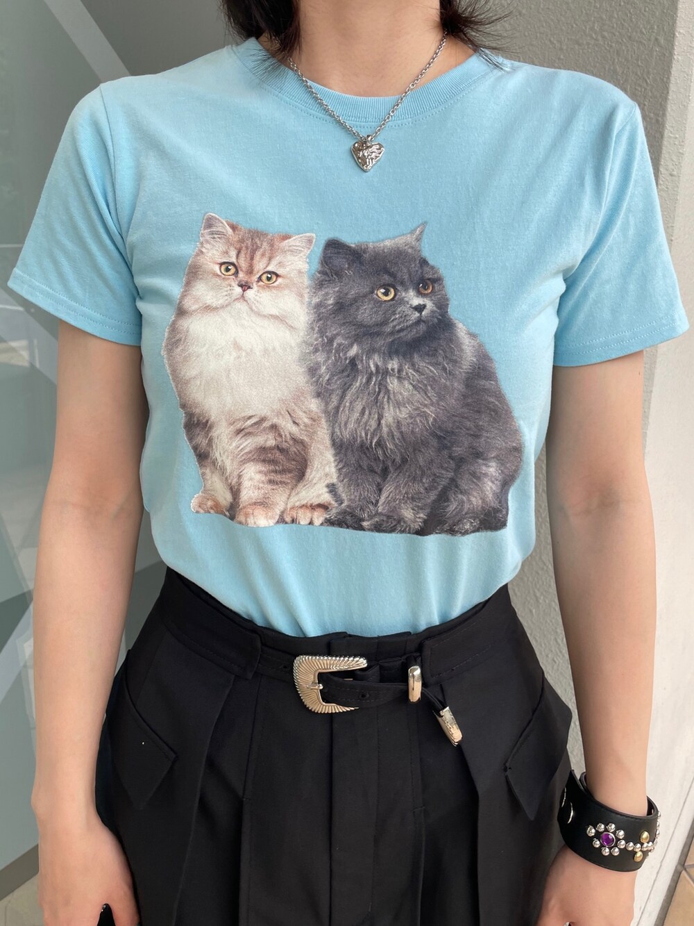 ブルー系のTシャツ/カットソー、ブラック系のスカート、シルバー系のハンドバッグを着用したレディースの春コーディネートの8枚目の写真