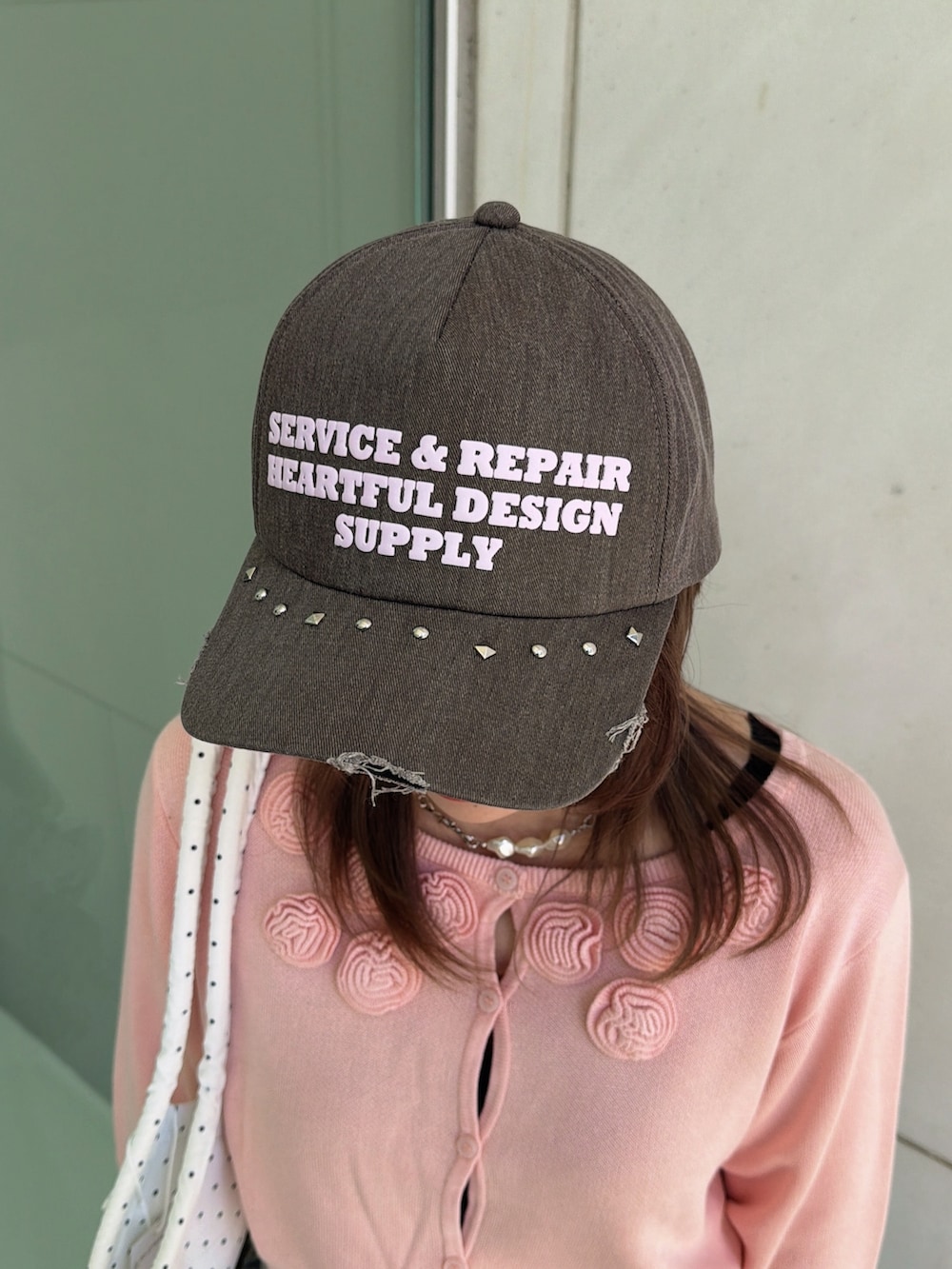 ピンク系のニット/セーター、ホワイト系のトートバッグ、ブルー系のデニムパンツを着用したレディースの春コーディネートの6枚目の写真