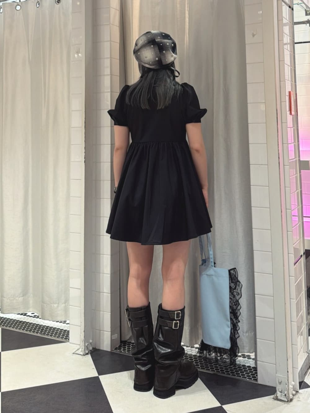 ブルー系のトートバッグ、ブラック系のワンピース、ブラック系のネクタイを着用したレディースの夏コーディネートの3枚目の写真