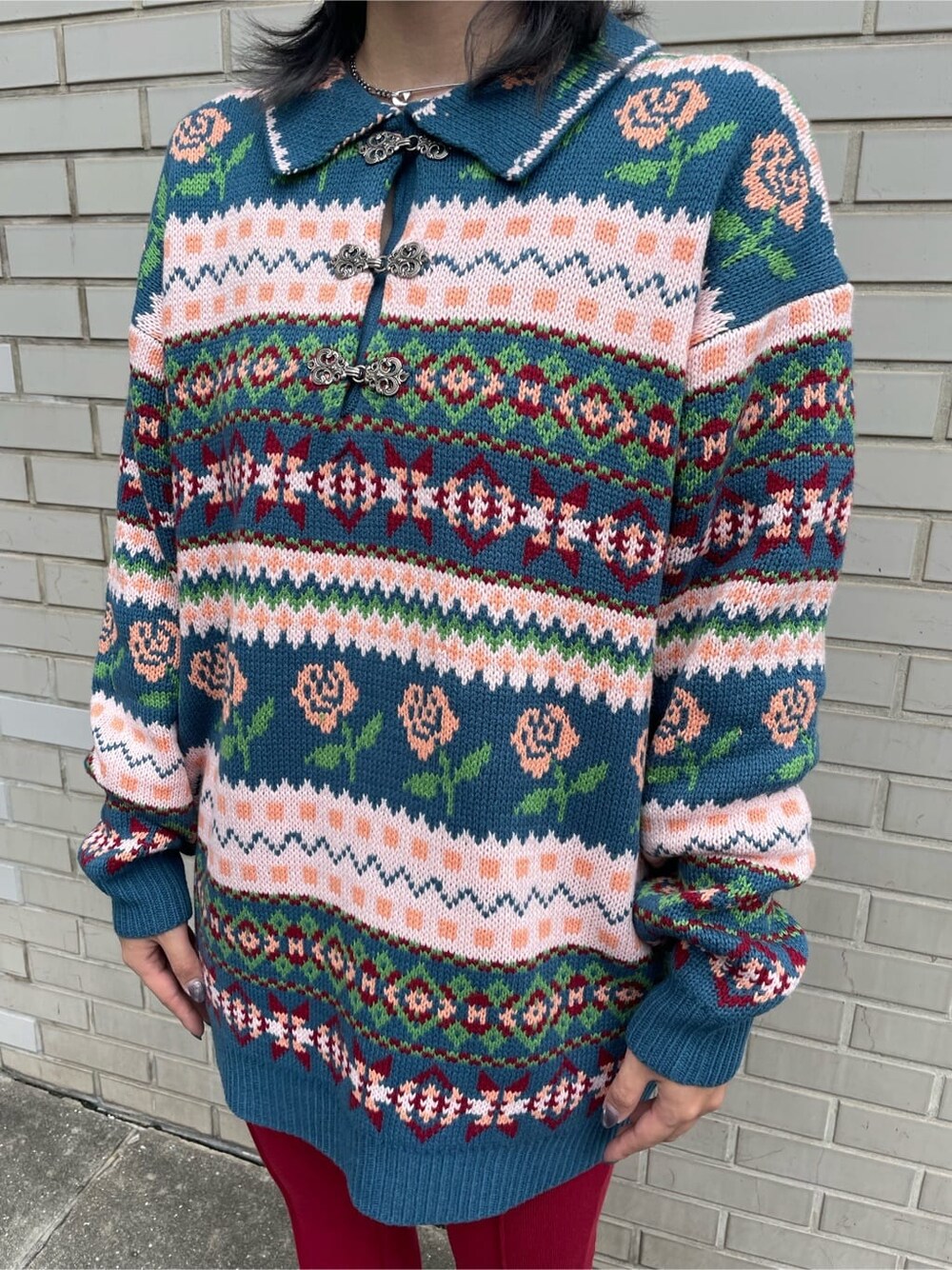 ブルー系のニット/セーター、レッド系のその他パンツ、シルバー系のネックレスを着用したレディースの秋コーディネートの4枚目の写真