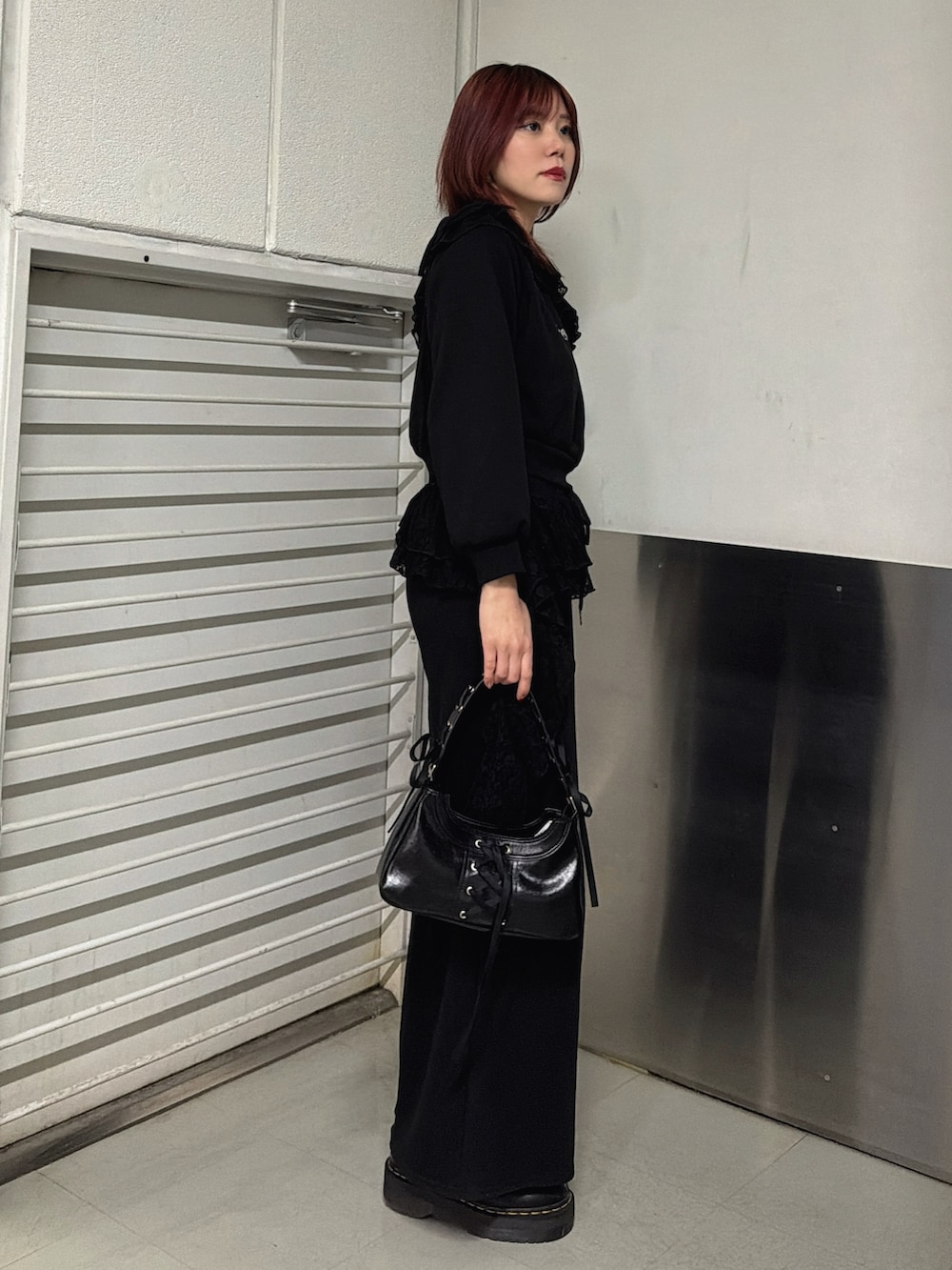 ブラック系のスウェットパンツ、ブラック系のハンドバッグ、ブラック系のスウェットを着用したレディースの冬コーディネートの2枚目の写真