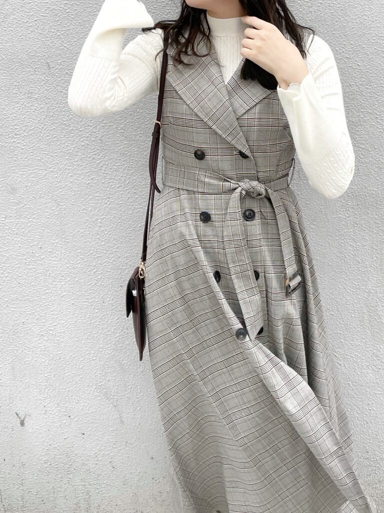 グレー系のワンピース、ホワイト系のニット/セーター、ホワイト系のパンプスを着用したレディースの秋コーディネートの5枚目の写真