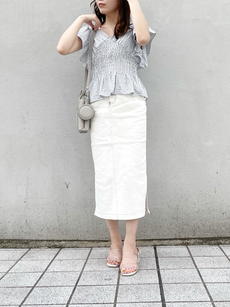 グレー系のハンドバッグ、ブルー系のシャツ/ブラウス、ホワイト系のスカートを着用したレディースの春コーディネートの3枚目の写真