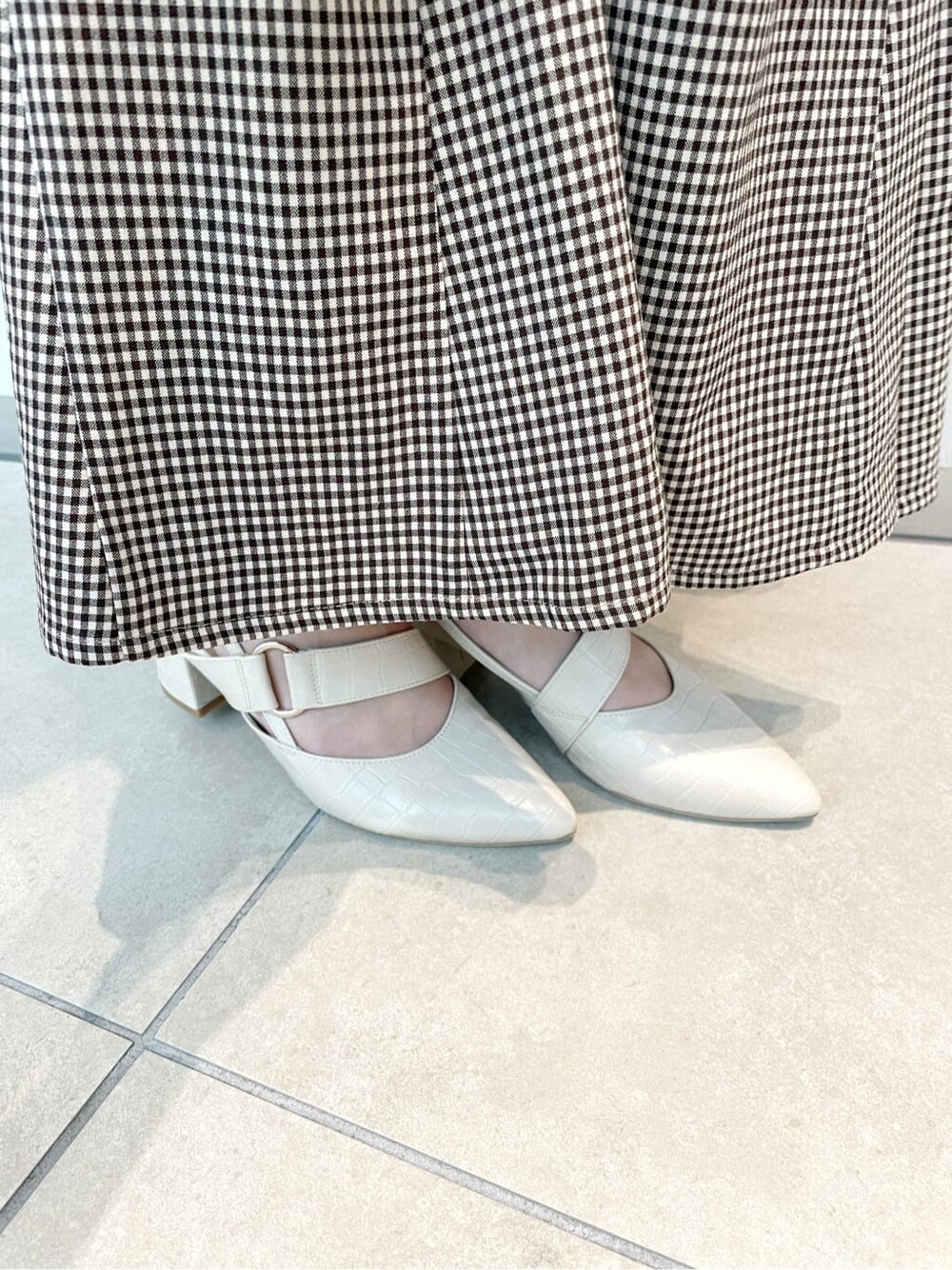 ブラウン系のスカート、ピンク系のニット/セーター、ベージュ系のハンドバッグを着用したレディースの秋コーディネートの8枚目の写真