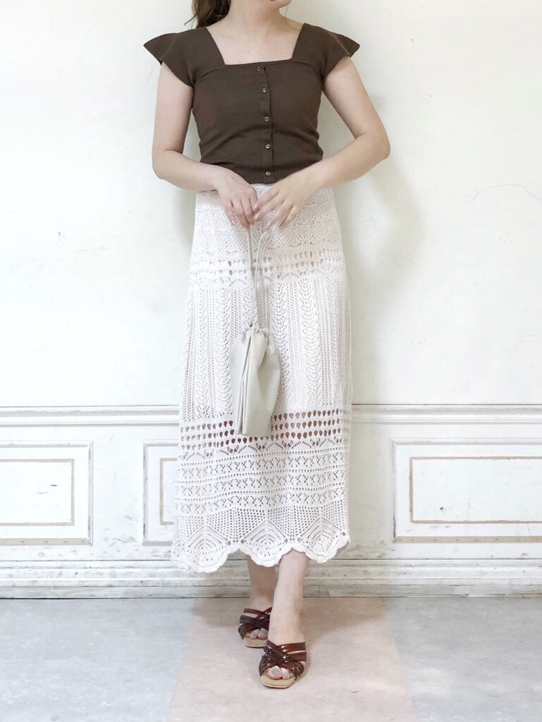 ホワイト系のスカート、ホワイト系のハンドバッグ、ブラウン系のサンダルを着用したレディースの夏コーディネートの2枚目の写真