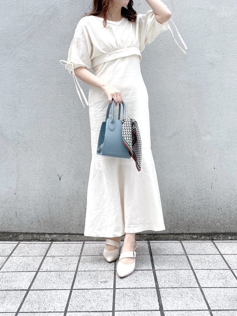 ホワイト系のワンピース、ブルー系のハンドバッグ、ホワイト系のパンプスを着用したレディースの春コーディネートの2枚目の写真