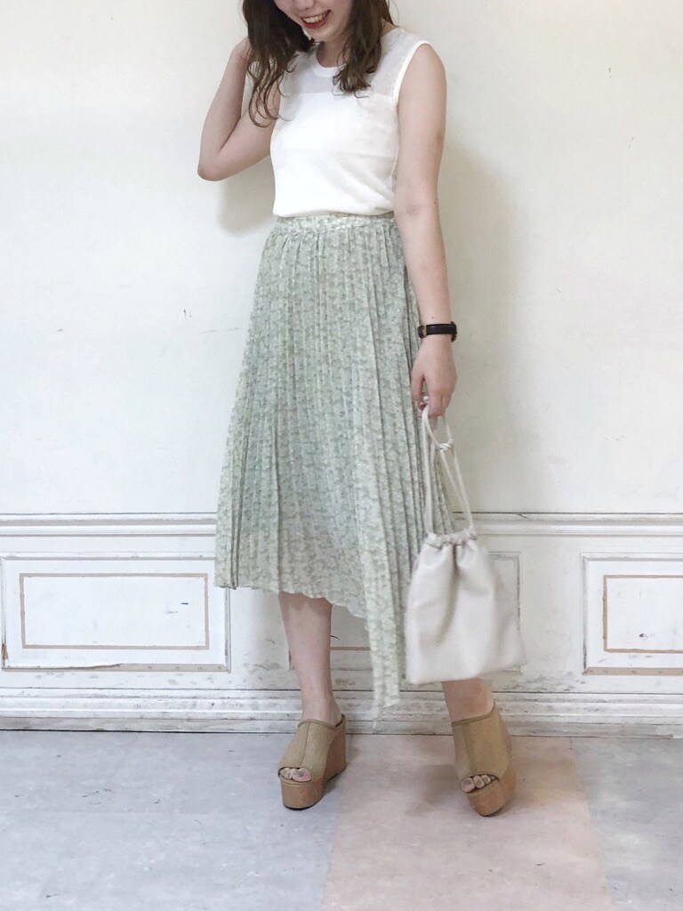 ホワイト系のニット/セーター、ホワイト系のハンドバッグ、グリーン系のスカートを着用したレディースの夏コーディネートの2枚目の写真