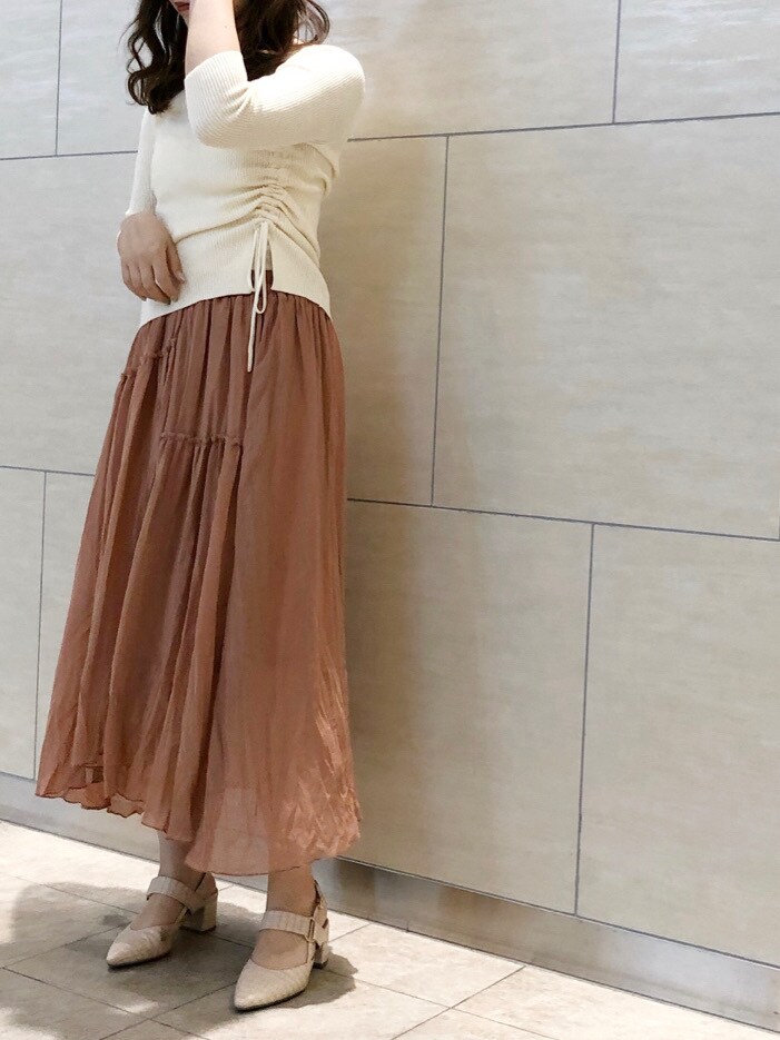 ベージュ系のトレンチコート、ブラウン系のスカート、ホワイト系のパンプスを着用したレディースの春コーディネートの3枚目の写真