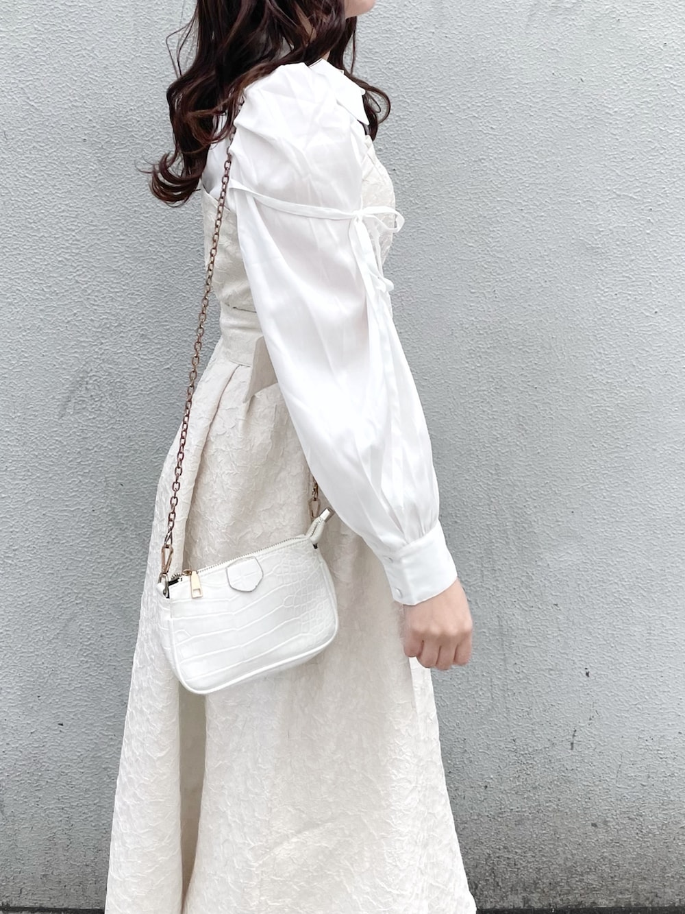 ホワイト系のワンピース、ホワイト系のパンプスを着用したレディースの冬コーディネートの6枚目の写真