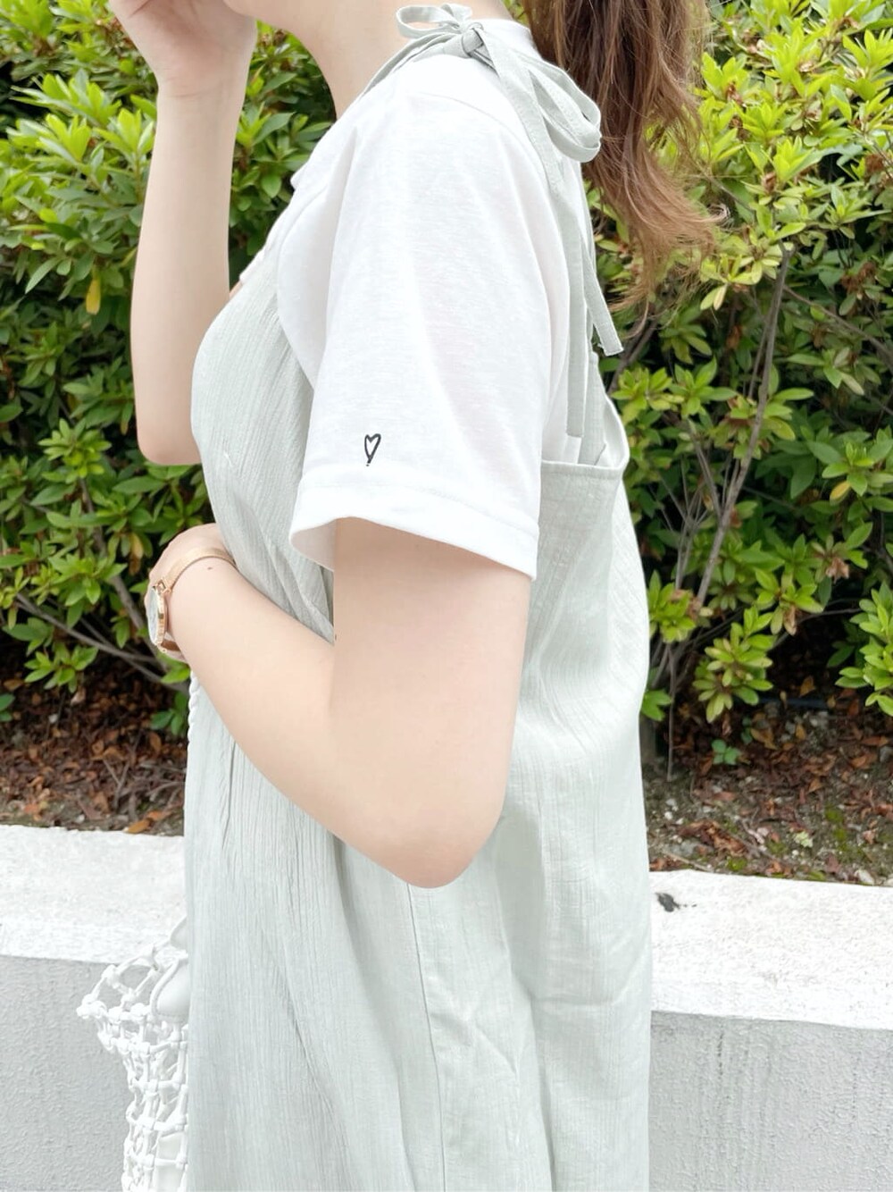 グリーン系のワンピース、ホワイト系のTシャツ/カットソー、ホワイト系のショルダーバッグを着用したレディースの夏コーディネートの7枚目の写真