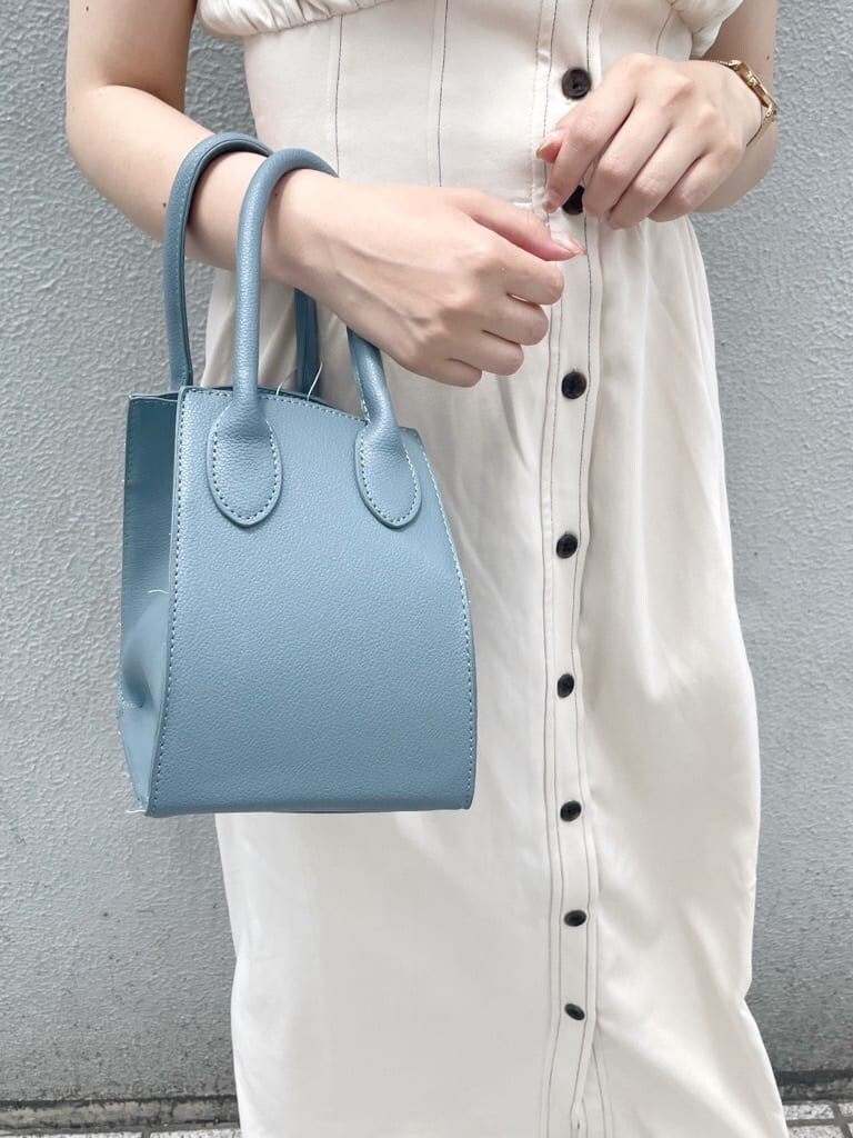 パープル系のサンダル、ブルー系のハンドバッグ、ホワイト系のワンピースを着用したレディースの夏コーディネートの7枚目の写真