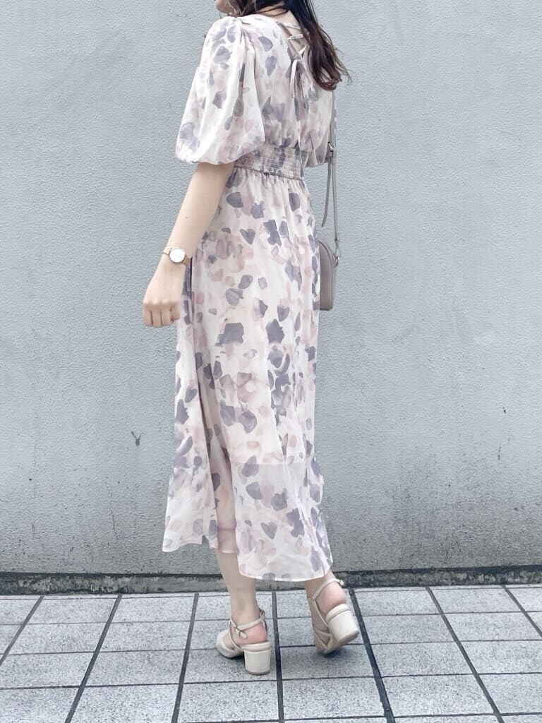 ピンク系のワンピース、ホワイト系のパンプス、ベージュ系のハンドバッグを着用したレディースの春コーディネートの2枚目の写真