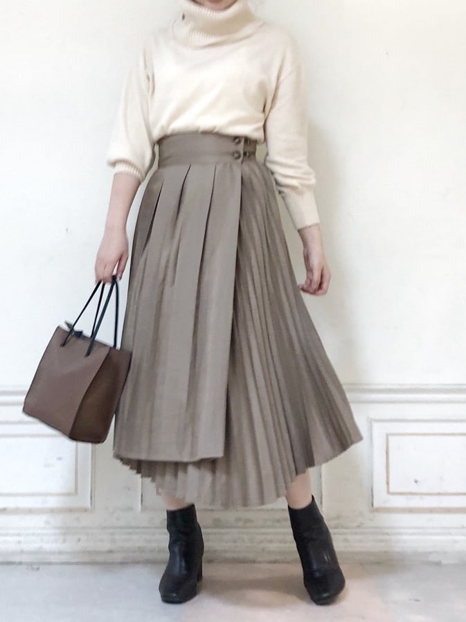 ブラウン系のハンドバッグ、ホワイト系のニット/セーター、ベージュ系のスカートを着用したレディースの秋コーディネートの2枚目の写真