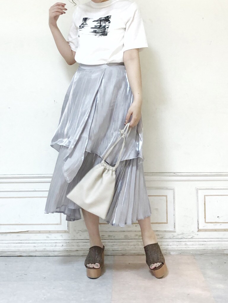 グレー系のスカート、ホワイト系のハンドバッグ、ホワイト系のTシャツ/カットソーを着用したレディースの夏コーディネートの3枚目の写真