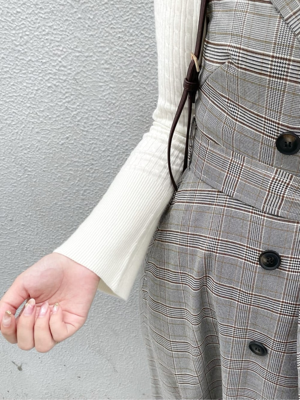 グレー系のワンピース、ホワイト系のニット/セーター、ホワイト系のパンプスを着用したレディースの秋コーディネートの7枚目の写真