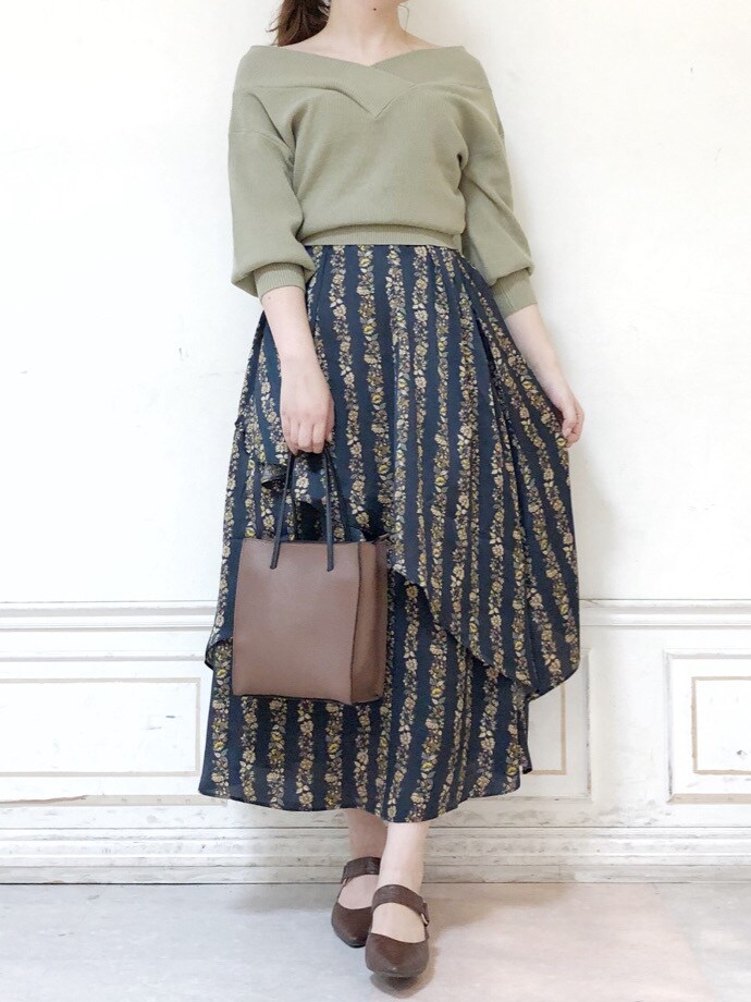 ブラック系のスカート、ブラウン系のハンドバッグ、グリーン系のニット/セーターを着用したレディースの秋コーディネートの4枚目の写真