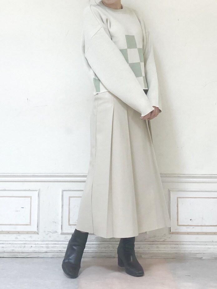 ベージュ系のスカート、グリーン系のニット/セーター、グリーン系のチェスターコートを着用したレディースの秋コーディネートの5枚目の写真
